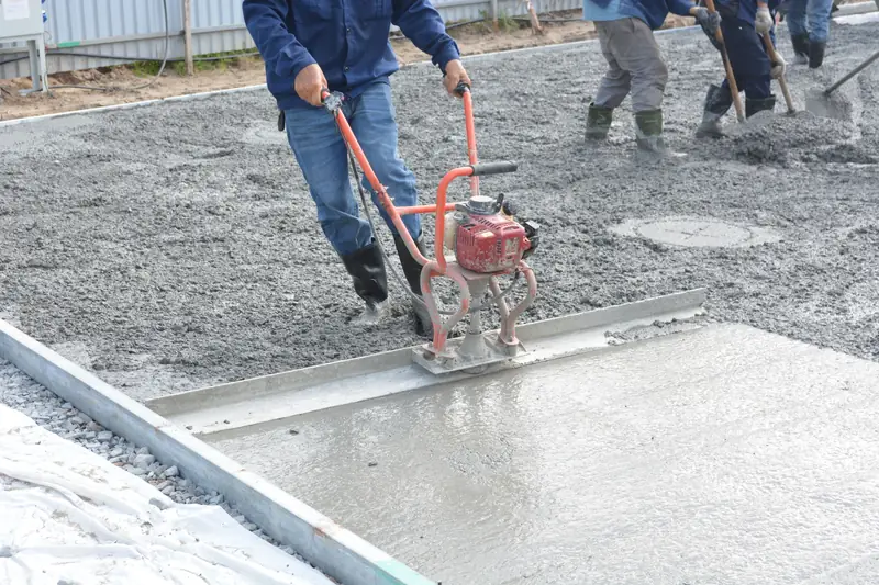Crew leveling freshly poured concrete with a power screed